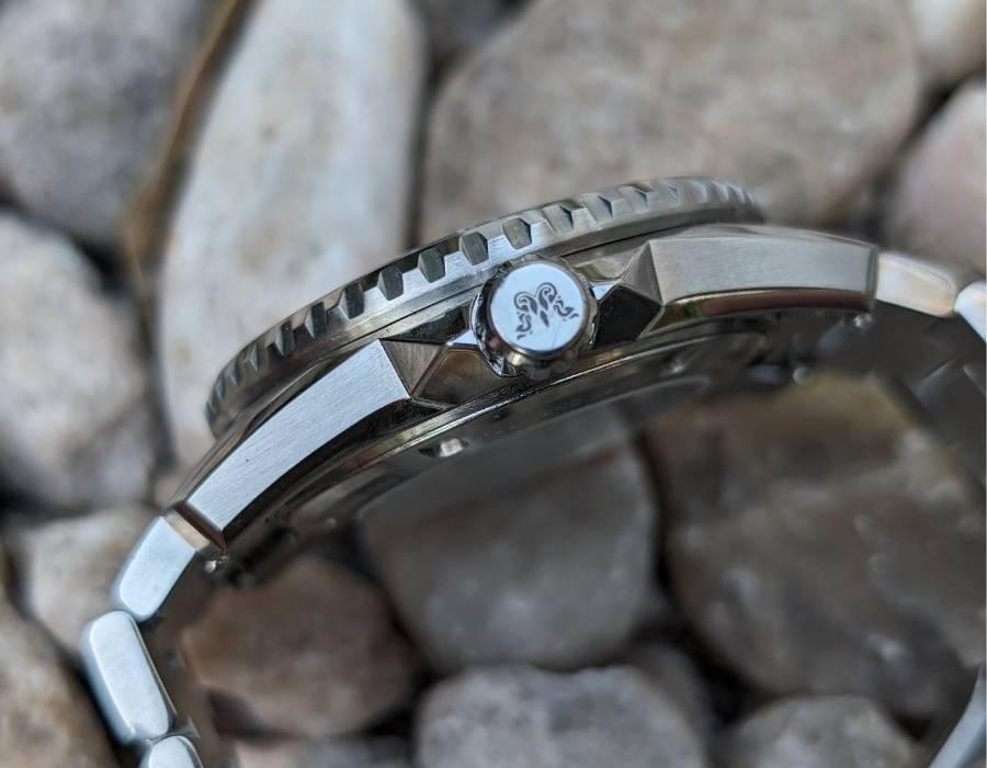 Side view of WISE ADX 110 True GMT watch showing engraved crown and stainless steel case